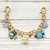 Fish bag chain with blue and green tropical fish charms, round blue beads, and rhinestone ball beads hanging on a gold chain with trigger clasps on each end. Fish bag charm.