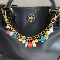 Tiny lampworked glass animals and lampworked floral beads hanging on a gold bag chain with trigger clasps on either end. Cute colorful bag chain for handbags.