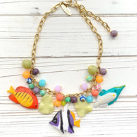 Tropical fish necklace for women. Colorful necklace for vacation outfit with tropical fish charms and assorted bright colored round beads on a gold chain.