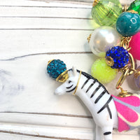 Embellished zebra figurine bag charm.