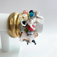 Bracelet stack inspiration. A charm bracelet with colorful beads, including red, green, blue, yellow, and purple stacked bangles. The bracelet also features small cat figurines in white, black, and gray. Gift for cat lovers. Lenora Dame jewelry.
