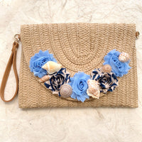 Straw woven clutch purse for women with removable strap. Embellished straw crossbody bag with seashells and fabric flower details. Cute straw clutch purses for women 2025.