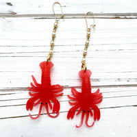 Red lobster dangle earrings for women with soft resin lobsters hanging by the tail from a chain made with 4 linked pearls, hung on French ear wires. Cute lobster earrings. Lenora Dame jewelry.
