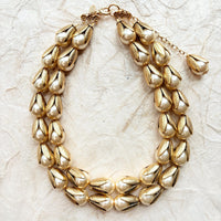 Two strand gold necklace with cream pearls encased in gold leaf bead caps. Lenora Dame necklace.