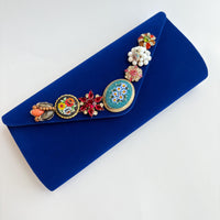 Royal blue velvet clutch purse detailed with seven vintage pearl and rhinestone earrings and miniature mosaic brooches.
