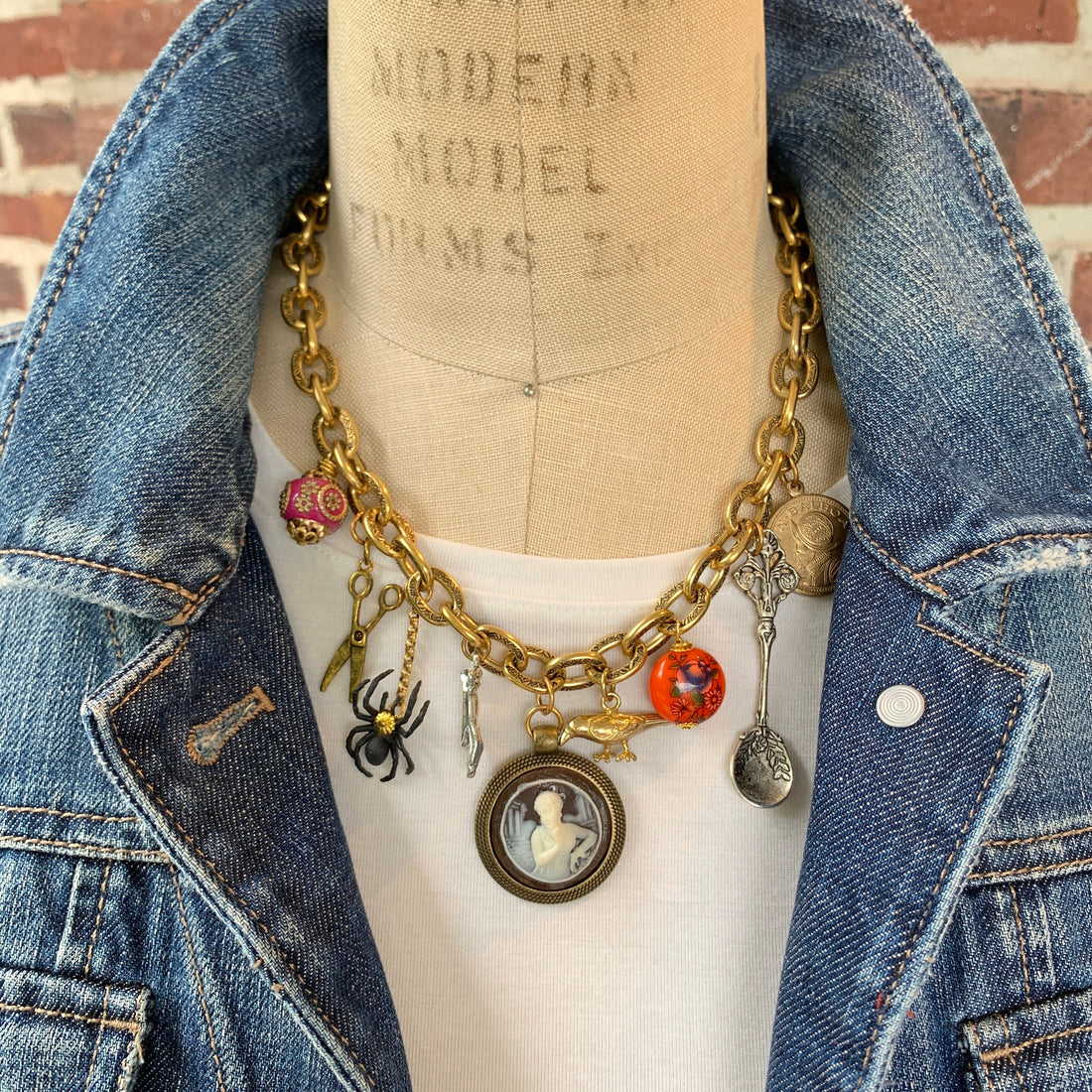 Statement necklace with a mix of vintage inspired charms hung on a thick gold chain. Vintage inspired statement necklace for women.