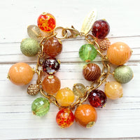 Beaded bracelet in fall colors for women. Orange chunky charm bracelet for women.