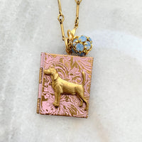 Gold locket necklace with brass dog metal stamping detail hung on a gold chain. Locket necklace for women.