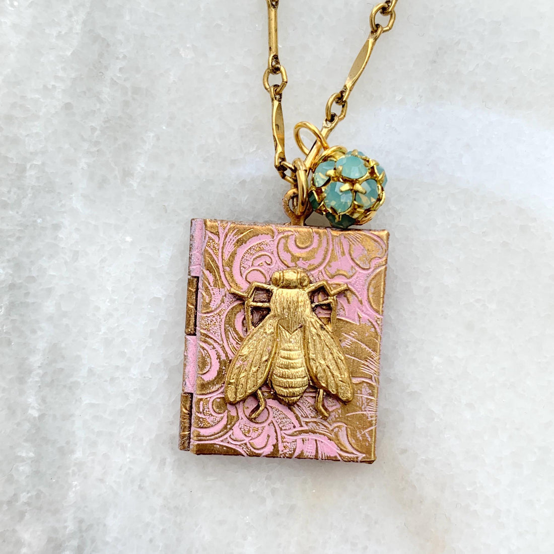 Gold locket necklace with brass honey bee metal stamping detail hung on a gold chain. Locket necklace for women.