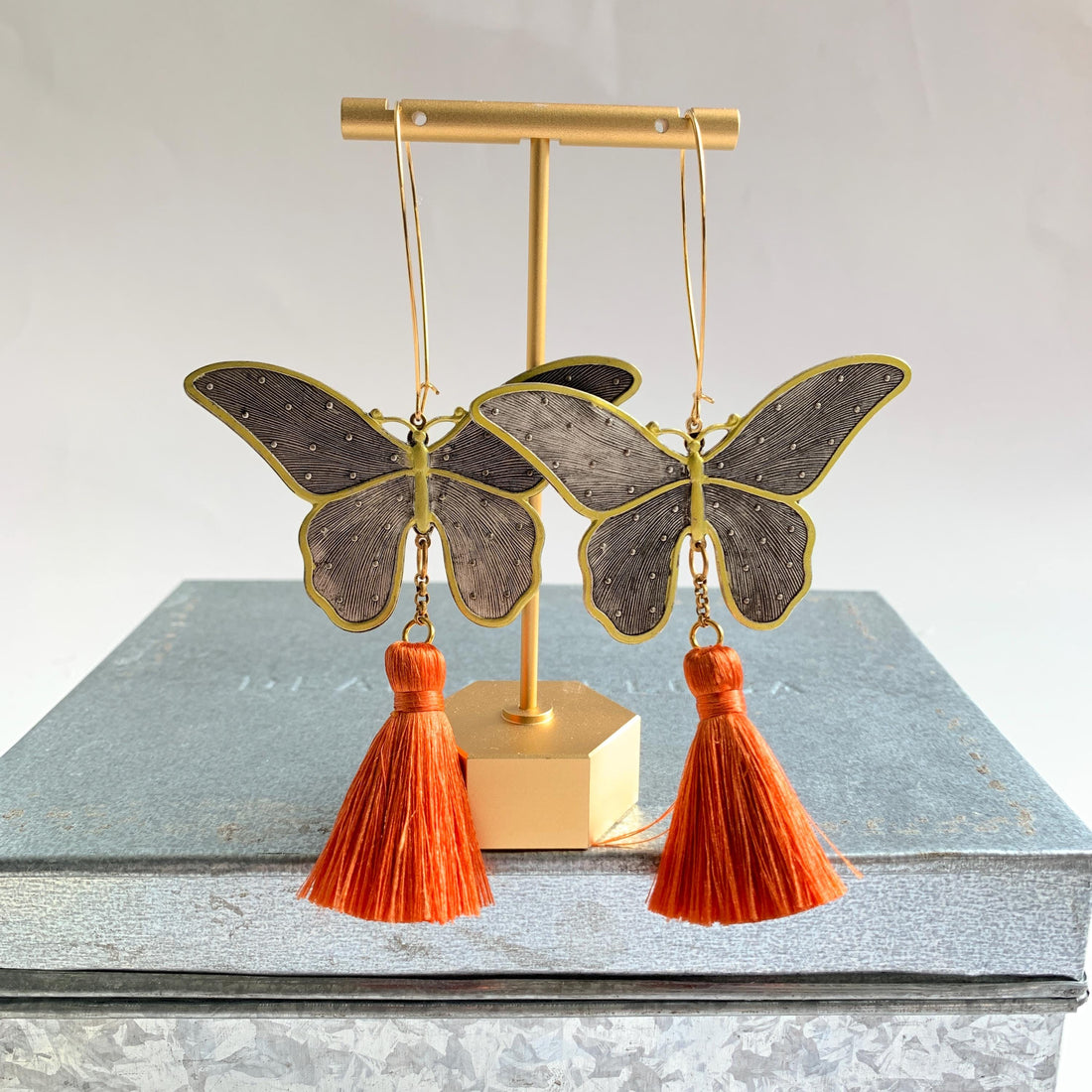 Butterfly earrings for women. Butterfly dangle earrings with silver butterflies and orange tassels.