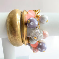 Lenora Dame charm bracelet stacked with two gold bangle bracelets for bracelet styling inspiration.