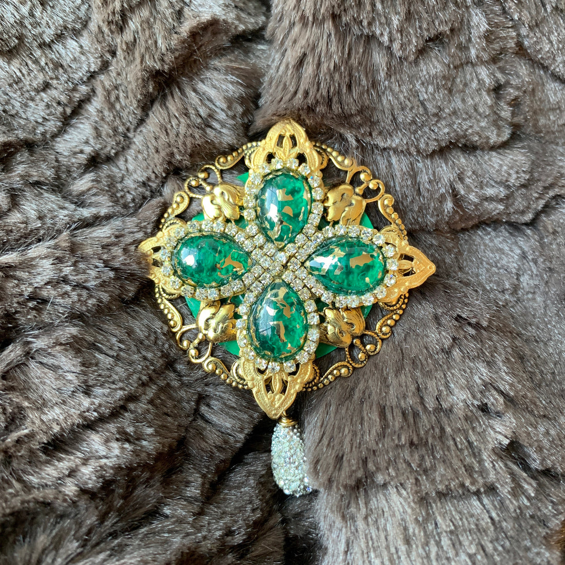 Gold rhinestone brooch with emerald green tear drop gemstones surrounded by crystal clear rhinestones. Vintage inspired lapel pin. 